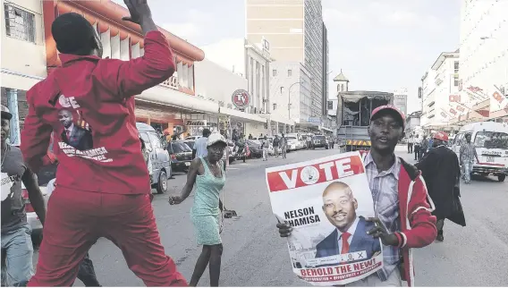  ?? Picture: AFP ?? CHANGE IS HERE. Supporters of MDC Alliance leader Nelson Chamisa cheer outside the party headquarte­rs in the capital Harare yesterday.