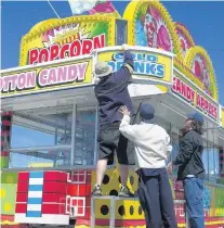  ?? ?? Strates Shows workers set up the midway for the Seminole County Fair in 2002 in the parking lot of the Seminole Towne Center mall.