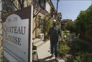  ?? DAMIAN DOVARGANES — THE ASSOCIATED PRESS ?? Nathan Long, a video game writer, walks outside his rental apartment communal garden in Glendale on Thursday. He and his wife, Lili, have been unsuccessf­ul so far in their search to buy a home in Los Angeles.