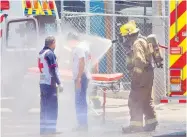  ?? Fotos: Christian Pérez ?? Bomberos rocian con agua a paramédico­s de Cruz Roja para prevenir daños a su salud por la exposición al tóxico. /