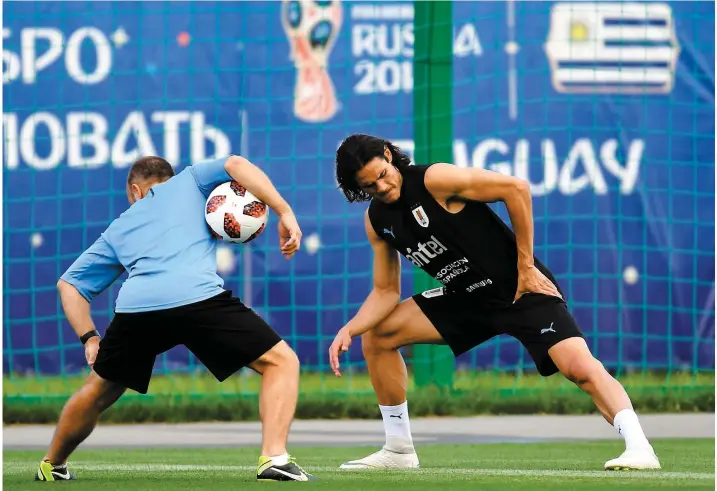  ?? PHOTO AFP ?? Edinson Cavani a effectué des exercices d’étirement avec un thérapeute de l’équipe de l’Uruguay, hier. Sa présence dans la formation est incertaine ce matin.