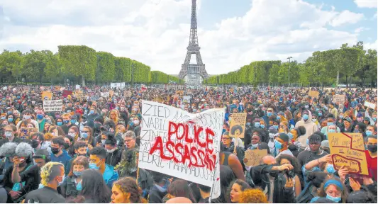  ?? AP ?? In this June 6 file photo, hundreds of demonstrat­ors gather near the Eiffel Tower, some with a banner reading ‘Police, murderers’, during a demonstrat­ion in Paris, France, to protest against the recent killing of George Floyd, a black man who died in police custody in Minneapoli­s, USA.