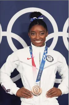  ?? Associated Press ?? Simone Biles, of the United States, poses wearing her bronze medal from balance beam competitio­n during artistic gymnastics at the 2020 Summer Olympics on Aug. 3 in Tokyo.