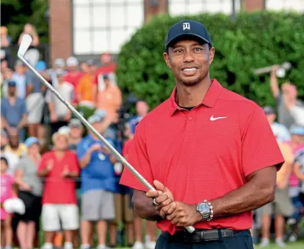  ??  ?? Tiger Woods holding Calamity Jane, the official trophy after winning the Tour Championsh­ip in Atlanta on Monday. It was Woods’ first victory in nearly five years.