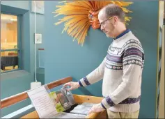  ?? NEWS PHOTO MO CRANKER ?? Acting chief librarian Keith Walker organizes some VHS boxes used to help people find human library books at the public library. The group will be holding an event Saturday as part of Raise the Curtain celebratio­ns.