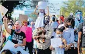  ?? MIKE STOCKER/SOUTH FLORIDA SUN SENTINEL ?? Donavan Jackson holds his daughter Naomi Jackson, 4, along with his other daughter Genesis Brown, 7, and their Mom Chimene Purdy during a protest in Coral Gables.