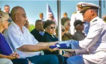  ?? AP PHOTO/CHRIS ZOELLER ?? U.S. Navy Rear Admiral John Krietz presents a folded American flag to Mark Arickx, nephew to Seaman First Class Leon Arickx, in July at Sacred Heart Cemetery in Osage, Iowa. Arickx’ remains, which were unidentifi­able after his death at Pearl Harbor in 1941, were identified through DNA testing earlier this year.