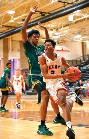  ?? Staff photo by Hunt Mercier ?? ■ Texas High’s Aaron Meeks drives to the basket for a layup under pressure from Longview’s Malik Henry on Monday at Tiger Gym in Texarkana, Texas.