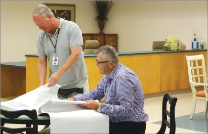  ?? KAYLA BAUGH/THREE RIVERS EDITION ?? Paul Hirleman, left, deputy director of the Lonoke County Council on Aging, studies building plans for the Cabot Senior Center with Buster Lackey, executive director of the council. Lackey said the center, which is set to open Wednesday, has been...