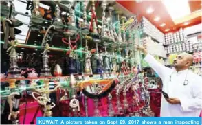  ?? — Photo by Yasser Al-Zayyat ?? KUWAIT: A picture taken on Sept 29, 2017 shows a man inspecting water-pipes at a shop in Kuwait City.