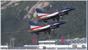  ?? Photo: Cui Meng/GT ?? Two J-10 fighter jets of the August 1 aerobatics team fly over the exhibition hall of the Airshow China 2018 on Tuesday.