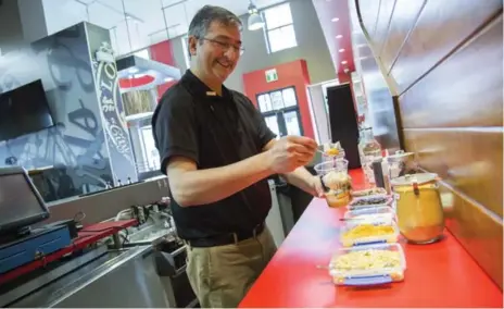  ?? ANNE-MARIE JACKSON/TORONTO STAR ?? P.K. Joshi, general manager of the new Carl’s Jr. on Queen St. W., whips up a at the restaurant’s dedicated frappe bar.