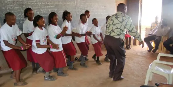  ?? SALLY ARMSTRONG ?? Paul Mwirigi, principal of the Ntani Primary School, joins the members of the Justice Club, a legacy of the 160 Girls decision, in a dance.