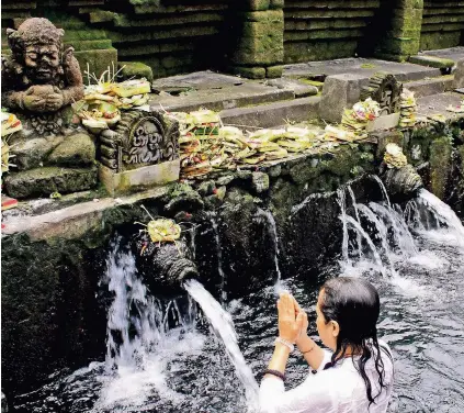  ??  ?? Waschstraß­e: Das Heilwasser der Tempelanla­ge Pura Tirta Empul soll von Göttin Indra höchstpers­önlich kommen.