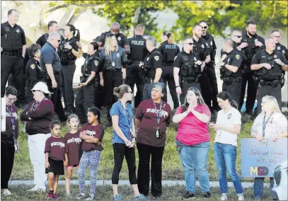  ?? Mike Stocker ?? South Florida Sun-sentinel Parents and police stand by as students head back to classes Wednesday at Marjory Stoneman Douglas High School in Parkland, Fla.