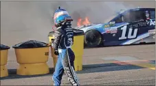  ?? Gaston De Cardenas / AP ?? Danica Patrick looks back as her car catches fire after hitting the wall on turn two during Sunday’s race at Homestead-Miami Speedway.