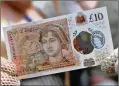  ?? CHRIS J. RATCLIFFE / POOL / GETTY IMAGES ?? People wearing period costumes Tuesday outside Winchester Cathedral in England displayed the new Jane Austen “tenner.”