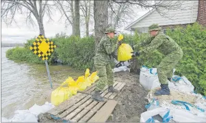  ?? CP PHOTO ?? Members of the Canadian army place sandbags next to rising floodwater­s in the Montreal borough of Pierrefond­s, Sunday, following flooding in the region.