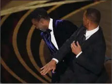  ?? (AP file/Chris Pizzello) ?? Will Smith (right) hits presenter Chris Rock on stage while Rock was presenting the award for best documentar­y feature at the Oscars on March 27 at the Dolby Theatre in Los Angeles.