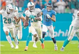  ?? PHOTOS BY JIM RASSOL/SUN SENTINEL ?? Safety Reshad Jones intercepts Titans quarterbac­k Blaine Gabbert’s pass attempt intended for Rishard Matthews in the fourth quarter help the Dolphins seal the game.