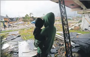  ?? AP PHOTO ?? Eshon Trosclair holds her son Camron Chapital after a tornado tore through home while they were inside Tuesday, Feb. 7, 2017 in the eastern part of New Orleans.