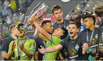  ?? TED S. WARREN/AP PHOTO ?? Seattle Sounders forward Raul Ruidiaz holds the trophy alongside teammate midfielder Nicolas Lodeiro after the Sounders defeated Pumas to win the CONCACAF Champions League soccer final Wednesday.