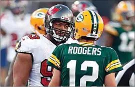  ?? JEFF HAYNES / AP ?? Buccaneers defensive end Ndamukong Suh (93) talks with Packers quarterbac­k Aaron Rodgers during the second half of an Oct. 18 game in Tampa, Fla. Rodgers had his worst game of the season in Green Bay’s 38-10 loss at Tampa Bay, as he threw two game-changing intercepti­ons and completed less than half his pass attempts.
