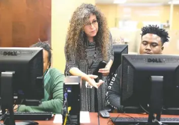  ?? STAFF PHOTOS BY ERIN O. SMITH ?? Rebecca Jacobs, a career specialist, works with Thomas Ellis, left, and Ricky Halfacre as they put together their resumes Thursday during a job fair event at the American Job Center.