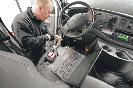  ?? STEVEN SENNE/AP ?? Brian Hohmann, the owner of Accurate Automotive in Burlington, Mass., attaches a diagnostic­s scan tool to a vehicle and a laptop computer. Hohmann said most independen­t shops are capable of competing with dealership­s on repair skills and price as long as they have the informatio­n they need.