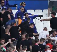  ??  ?? MORE VIOLENCE: Fans in the Hungary section clash with police before yesterday’s match against Iceland