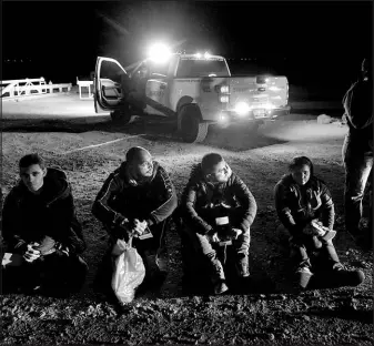  ?? GREGORY BULL / ASSOCIATED PRESS ?? Migrants wait to be processed after crossing the border Jan. 6 near Yuma, Ariz. The Biden administra­tion says it will generally deny asylum to migrants who show up at the U.S. southern border without first seeking protection in a country they passed through. That mirrors an attempt by the Trump administra­tion that never took effect because it was blocked in court.