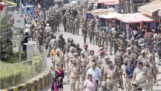  ?? — AFP ?? Paramiltar­y forces and police march in Jalandhar on Sunday.