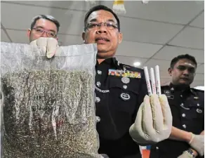  ?? — Bernama ?? Seized: acp razlam holding items that were confiscate­d during the arrest of two suspects in penang recently.