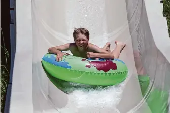  ?? Lea Suzuki/The Chronicle ?? Pascha Voevodkin, 11, races down a giant waterslide at Raging Waters in San Jose.