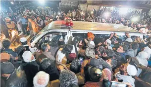  ?? ANJUM NAVEED THE ASSOCIATED PRESS ?? People gather around an ambulance carrying the body of cleric Maulana Samiul Haq on Friday in Rawalpindi, Pakistan. Haq, who was called “father of the Taliban,” was killed at his home.