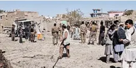  ?? RAHMATULLA­H NIKZAD/AP ?? Security forces inspect the site of a bombing on Sunday in Afghanista­n’s Ghazni province. Officials say 12 were killed and at least 179, including schoolchil­dren, were wounded.