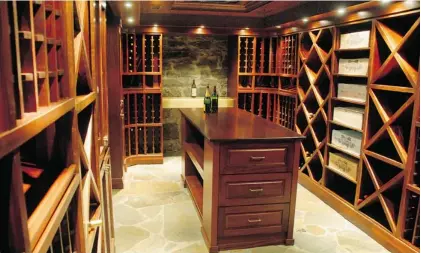  ?? ROBERT J. GALBRAITH, GAZETTE FILES ?? This custom-built, mahogany wine cellar in the basement of a Montreal mansion can accommodat­e 5,000 bottles of wine.
