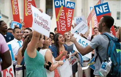  ??  ?? Jóvenes universita­rios celebran ante el Tribunal Supremo de Estados Unidos en Washington D.C, el dictamen que avala proveer subsidios fiscales a los beneficiar­ios pobres del Obamacare en todo el país.