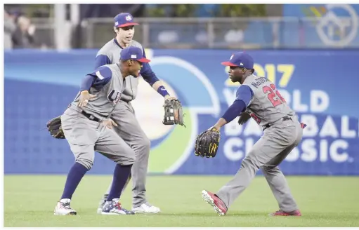  ??  ?? Adam Jones, left, of the US, Christian Yelich and Andrew McCutchen (22) celebrate after beating the Dominican Republic at Petco Park in San Diego, California, on Saturday night. (AFP)