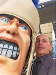  ??  ?? John Armato, director of community relations for the Pottstown School District, takes a selfie with Trojan Man.