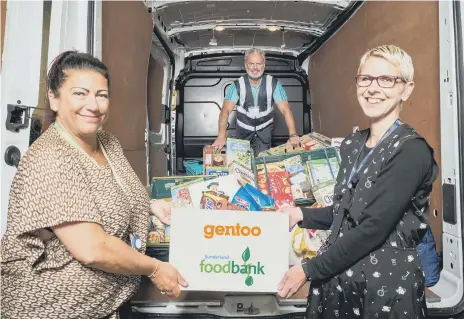  ??  ?? Gentoo’s community partnershi­p coordinato­r Angela Sinclair, left, gives a helping hand to food bank coordinato­rs Tommy Mellefont and Jo Gordon.