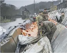  ??  ?? BARRIERS: Soldiers erect flood defences ahead of Storm Dennis.