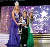  ?? (Special to the Democrat-Gazette) ?? Amelia Lisowe, 10, of Benton (center) was crowned winner of the Internatio­nal Project Purple competitio­n at the Royal Internatio­nal Miss pageant in Orlando, Fla., in July. Contestant­s were given 2 yards of fabric each and tasked with making and modeling their own outfit in five days.