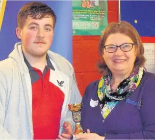  ??  ?? Runner-up in the U21 boys’ singles consolatio­n, George McDonnell, receives his trophy from Ros Gregory of Runcorn Rotary Club.