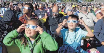  ?? FOTO: DPA ?? Schaulusti­ge beobachten – mit den nötigen Schutzbril­len – die totale Sonnenfins­ternis.