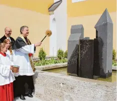  ??  ?? Die Pfarrer Erik Herrmanns (hinten links) und Andreas Straub segneten den neuen Stadtviert­elbrunnen, den die Bürgerstif­tung mit ihren Paten finanziert hat.