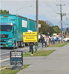  ?? ?? Anti-vaccine protesters outside Woodend School in North Canterbury at pickup time last Tuesday afternoon.