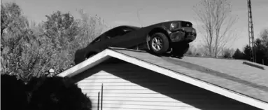  ?? The Associate
d Pres ?? A Ford Mustang on the roof of a house in Woodhull Township, Mich., in October.
Police said the driver had a medical problem and lost control of his car.