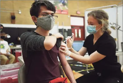  ?? Brian A. Pounds / Hearst Connecticu­t Media ?? Alexander Pereira, 15, of Milford, receives the Pfizer Covid-19 vaccine from nurse Kaitlin Erickson at a Yale New Haven Health vaccinatio­n clinic at the Parsons Complex gymnasium in Milford on Monday.