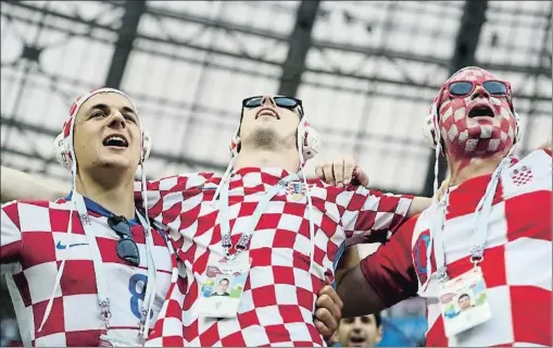  ?? CARL RECINE / REUTERS ?? Tres seguidores de Croacia animan a su selección en Rusia ataviados con gorros de waterpolo